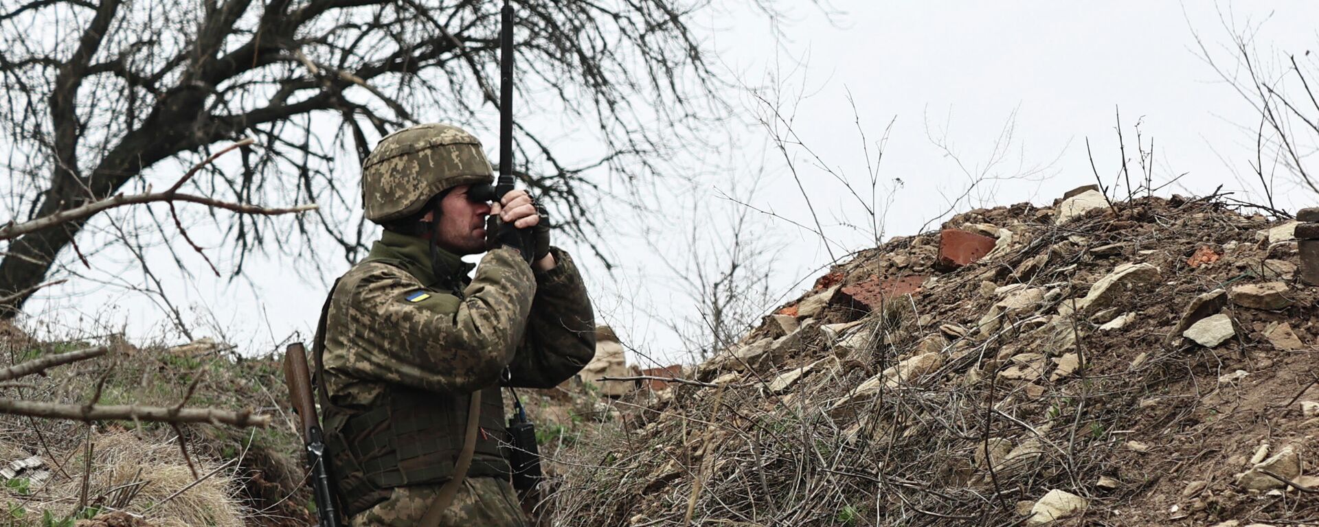 FILE - In this April 12, 2021, file photo, Ukrainian soldier watches through a periscope at fighting positions near Donetsk, Ukraine - Sputnik भारत, 1920, 23.12.2023