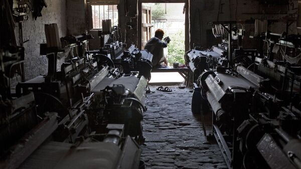 A textile worker waits for power to return at a loom factory in Pakistan - Sputnik India