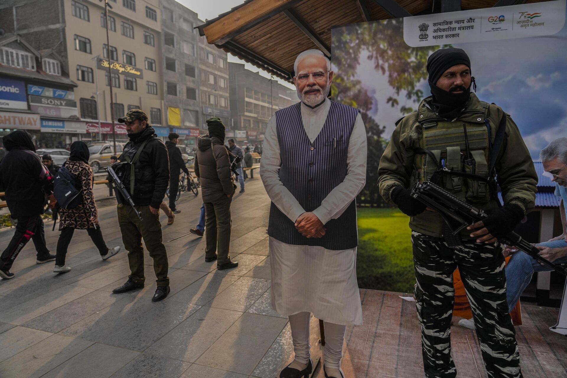 Indian paramilitary soldiers and policemen guard near a cutout portrait of Indian Prime Minister Narendra Modi displayed at the main market in Srinagar, Monday, Dec. 11, 2023. - Sputnik India, 1920, 26.02.2024