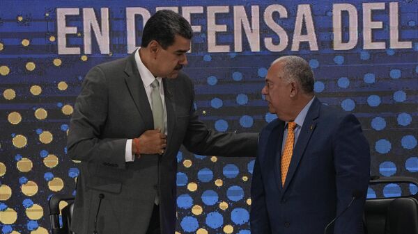 Venezuela's President Nicolas Maduro, left, speaks to National Electoral Council President Elvis Hidrobo Amoroso during the notification ceremony for the referendum about the future of a disputed territory with Guyana, in Caracas, Venezuela, Monday, Dec. 4, 2023. - Sputnik भारत