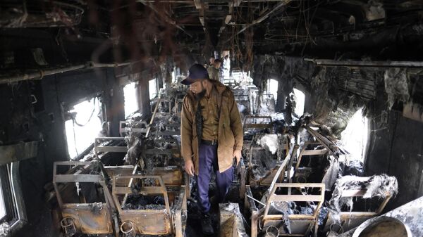 A security officer inspects the damage inside a passenger train that caught fire, killing four people in Dhaka, Bangladesh, Tuesday, Dec. 19, 2023.  - Sputnik India