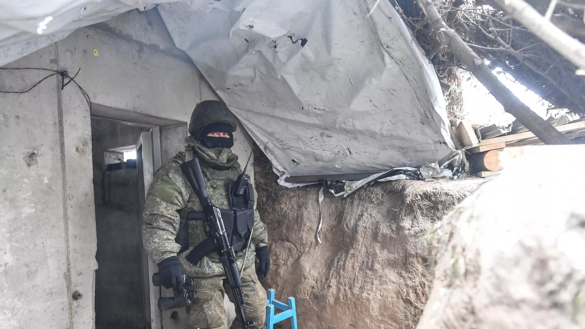 A Russian serviceman leaves a bunker in a trench at a position in the special military operation zone