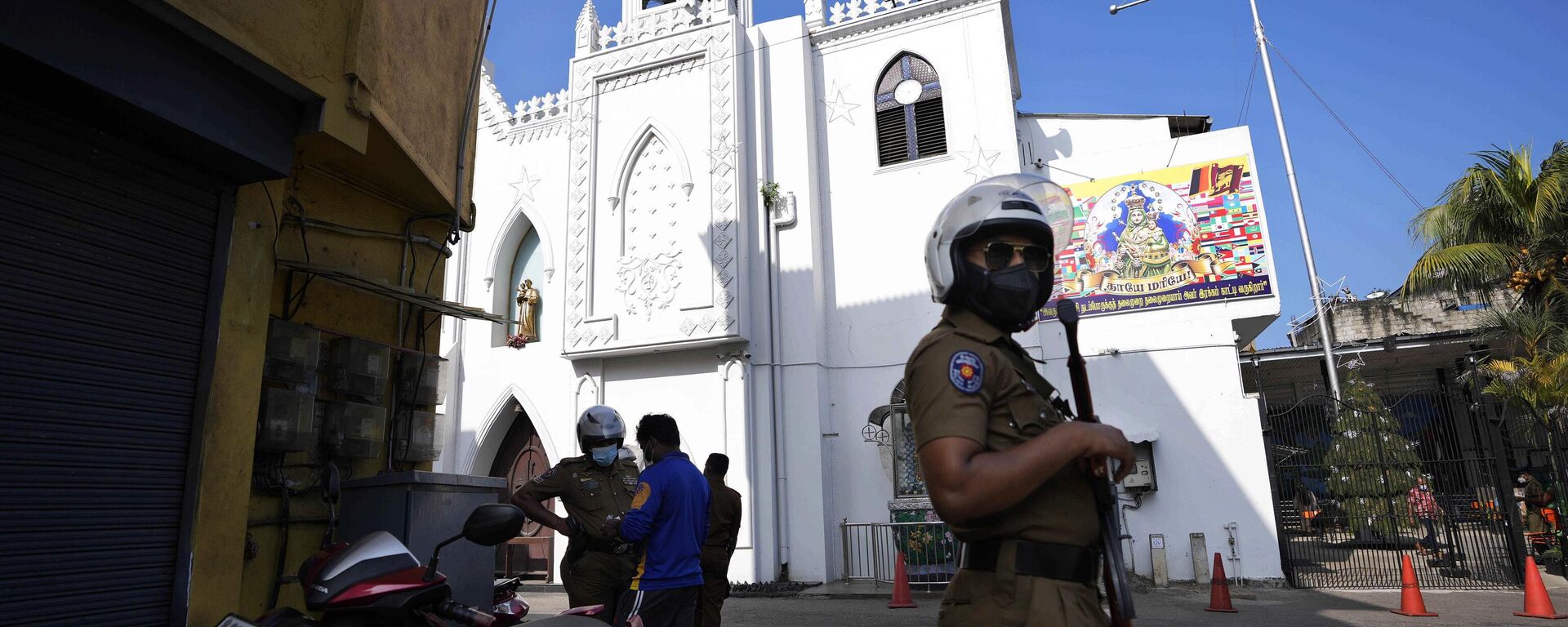 A Sri Lankan police officer stands guard outside at a church during Christmas festivities in Colombo, Sri Lanka, Saturday, Dec. 25, 2021. - Sputnik India, 1920, 25.12.2023