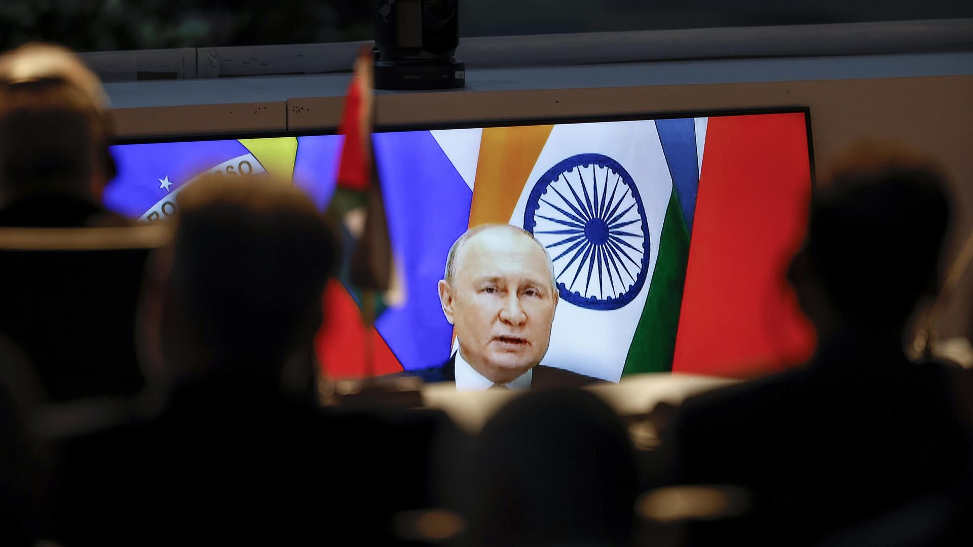 A screen shows Russian President Vladimir Putin via video link delivering remarks as delegates look on while attending a meeting during the 2023 BRICS Summit at the Sandton Convention Centre in Johannesburg Thursday, Aug. 24, 2023.  - Sputnik भारत, 1920, 01.02.2024