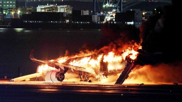 This photo provided by Jiji Press shows a Japan Airlines plane on fire on a runway of Tokyo's Haneda Airport on January 2, 2024. - Sputnik भारत
