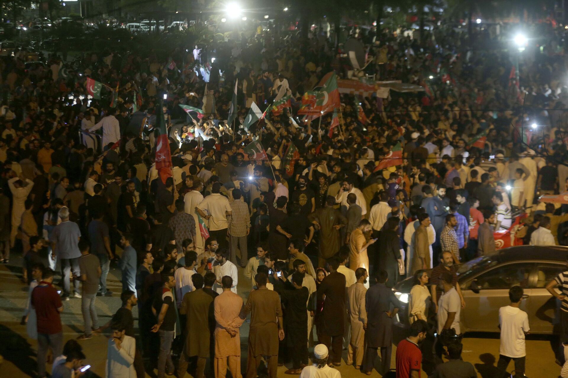 Supporters of former Pakistani Prime Minister Imran Khan's 'Pakistan Tehreek-e-Insaf' party block a road as protest against against provincial assembly's deputy speaker, Dost Mohammad Mazari for his ruling to invalidate 10 votes in the chief minister elections, in Lahore, Pakistan, Friday, July 22, 2022.  - Sputnik India, 1920, 13.01.2024