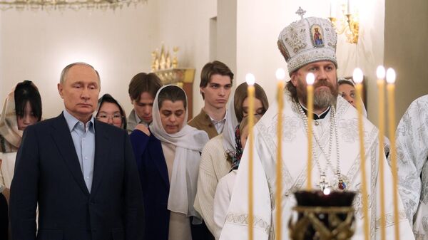 Russian President Vladimir Putin and Archbishop Foma of Odintsovo and Krasnogorsk attend the Orthodox Christmas service at the Church of the Not-Made-By-Hands Image of Christ the Saviour at Novo-Ogaryovo state residence outside Moscow, Russia - Sputnik भारत