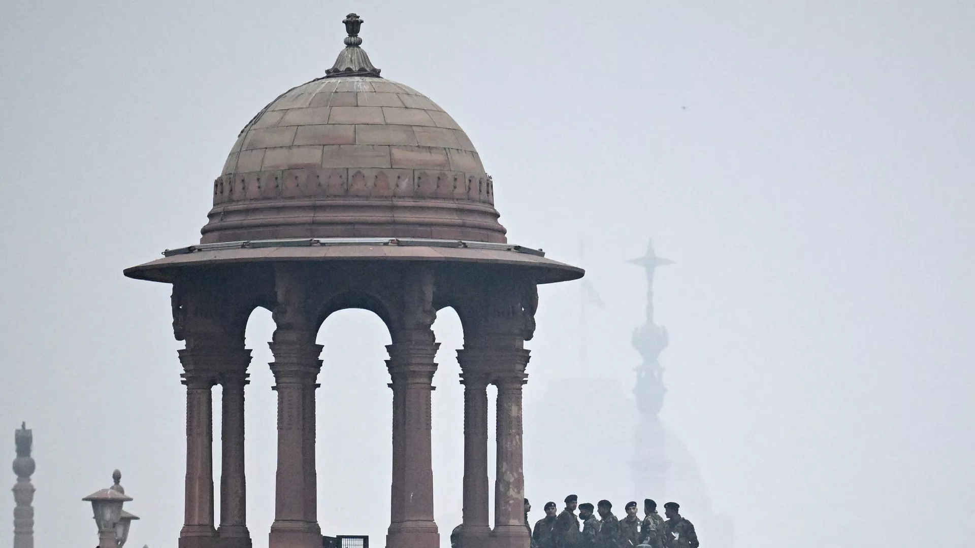 Security personnel stand guard in front of India's presidential palace Rashtrapati Bhavan on a cold foggy winter morning in New Delhi on January 4, 2024. 