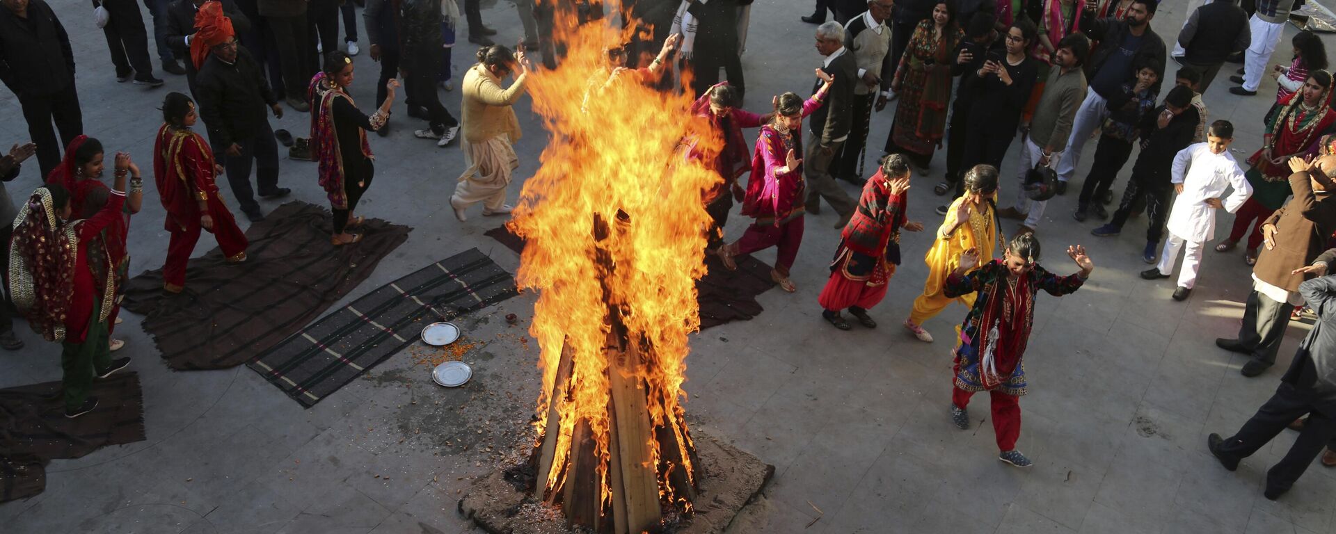 Indian girls in traditional attire dance around a bonfire as they celebrate Lohri festival in Jammu, India, Sunday, Jan. 13, 2019. Lohri is a celebration of the winter solstice observed by Hindus and Sikhs in northern India. (AP Photo/Channi Anand) - Sputnik India, 1920, 08.01.2024