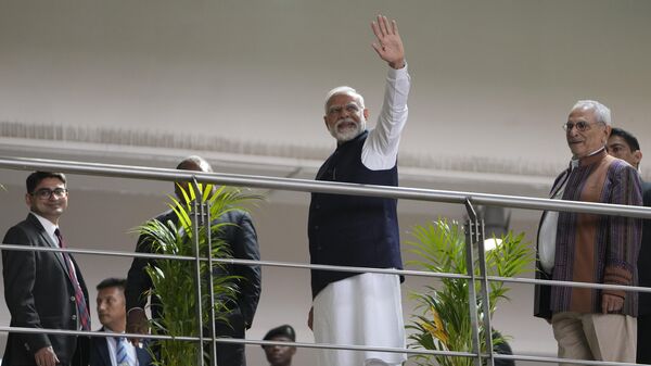 Indian Prime Minister Narendra Modi waves to people during the Vibrant Gujarat Global Summit, a business event to attract investments to the Gujarat state, in Gandhinagar, India, Wednesday, Jan. 10, 2024. - Sputnik भारत