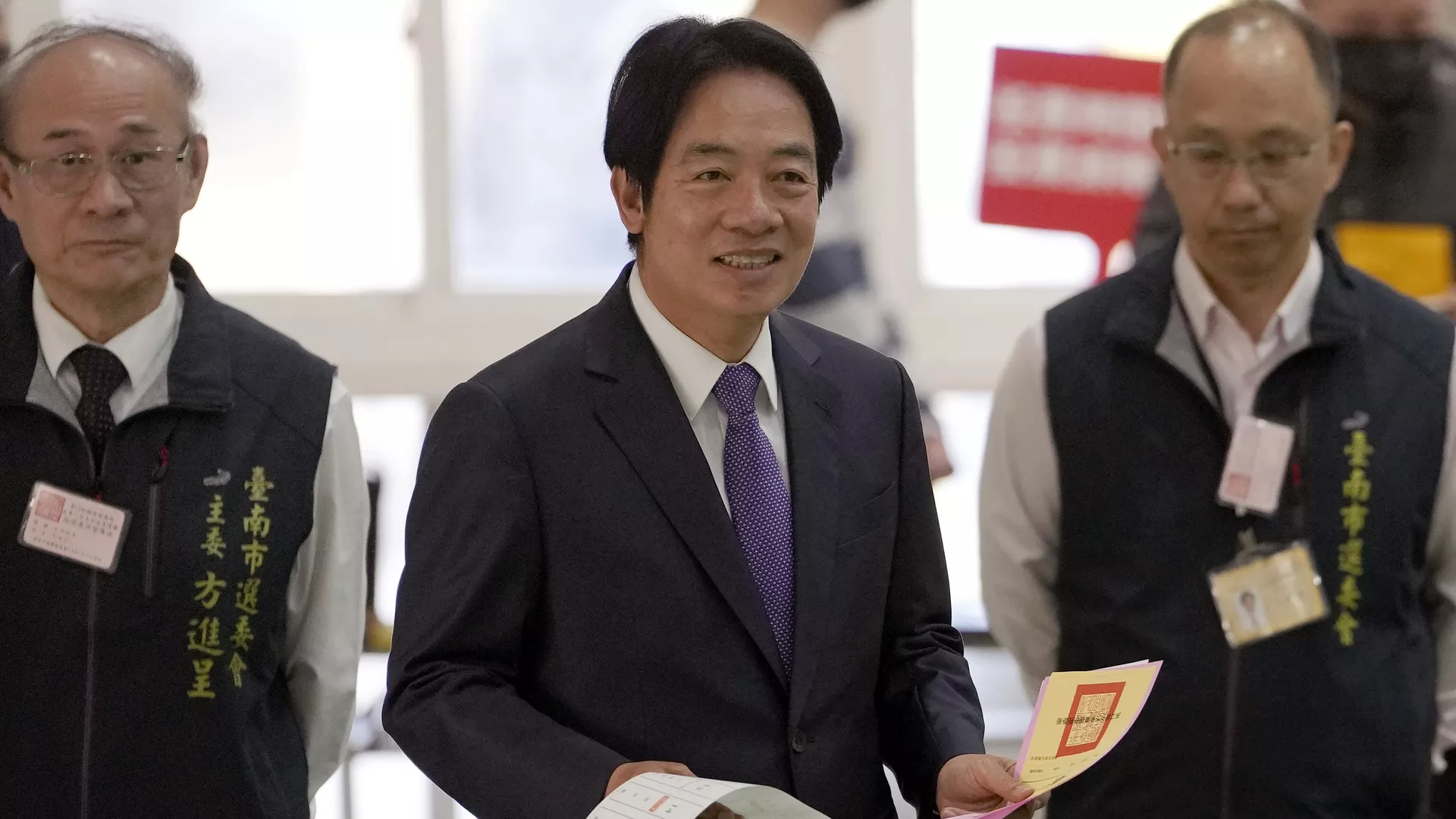 Democratic Progressive Party presidential candidate Lai Ching-te, center, who also goes by William, walks with ballot papers to cast at a polling station in southern Taiwan's Tainan city on Saturday, Jan. 13, 2024. 