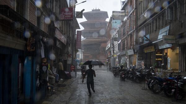 A man runs with an umbrella in the monsoon rain in Kathmandu, Nepal, Monday, June 26, 2023. - Sputnik भारत