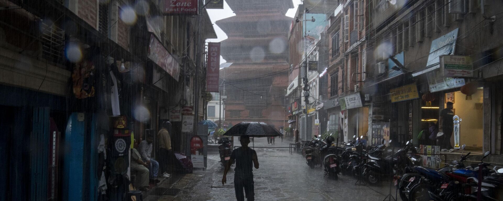 A man runs with an umbrella in the monsoon rain in Kathmandu, Nepal, Monday, June 26, 2023. - Sputnik भारत, 1920, 14.01.2024