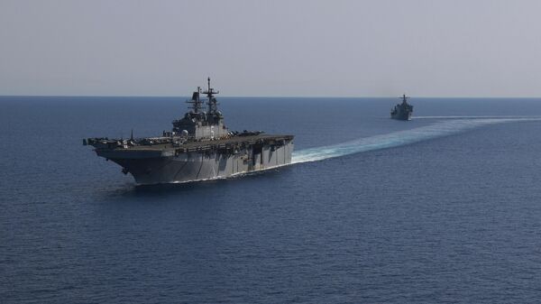 In this photo released by the U.S. Navy, the amphibious assault ship USS Bataan, front, and the landing ship USS Carter Hall, back travel through the Red Sea - Sputnik India