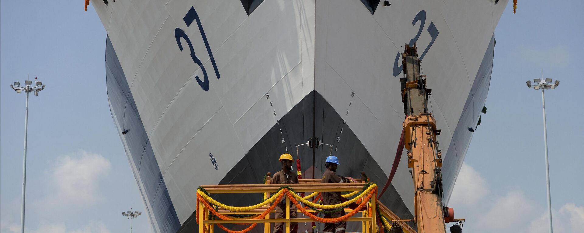 Workers give final checks to the Indian Coast Guard offshore patrol vessel 'Vajra' during the launch ceremony at the Larsen & Toubro shipyard on outskirts of Chennai on February 27, 2020. - Sputnik भारत, 1920, 24.01.2024