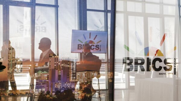 Delegates walk past the logos of the BRICS summit during the 2023 BRICS Summit at the Sandton Convention Centre in Johannesburg on August 23, 2023. - Sputnik India
