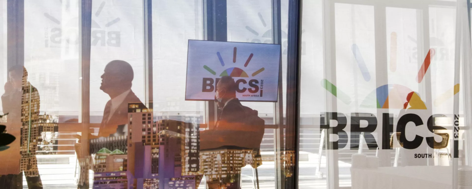 Delegates walk past the logos of the BRICS summit during the 2023 BRICS Summit at the Sandton Convention Centre in Johannesburg on August 23, 2023. - Sputnik भारत, 1920, 19.06.2024