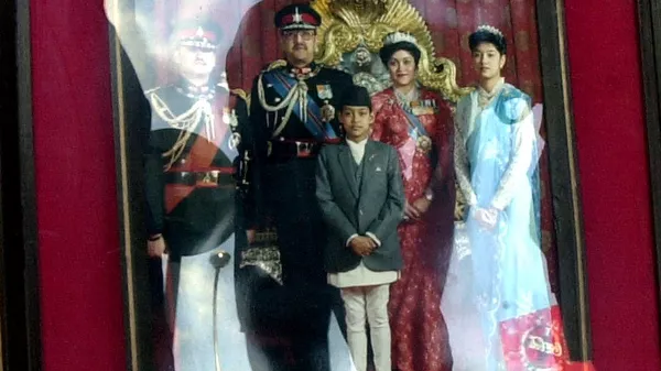 Nepalese security personnel, reflected on the photograph, look at a photograph of the Nepalese Royal family members who died in the palace massacre on June 01, on the street in front of the Royal Palace in Kathmandu, 09 June 2001. - Sputnik भारत