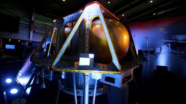 A delegate speaks on his phone next to a scale model of spacecraft displayed at a stall on the first day of the Bengaluru Space Expo 2016, in Bangalore, India, Thursday, Sept. 1, 2016. - Sputnik भारत