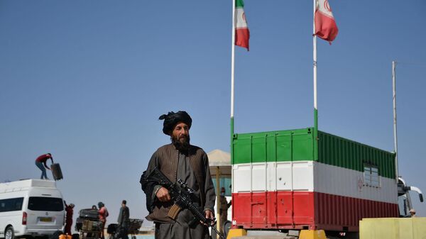 In this picture taken on October 19, 2021 a Taliban fighter stands guard at the Islam Qala border between Iran and Afghanistan. Iran is sending tens of thousands of Afghan migrants back to Taliban-ruled Afghanistan every week despite the threat of famine, aid agencies and witnesses say, with many Afghans alleging they have been mistreated by Iranian authorities. - Sputnik भारत