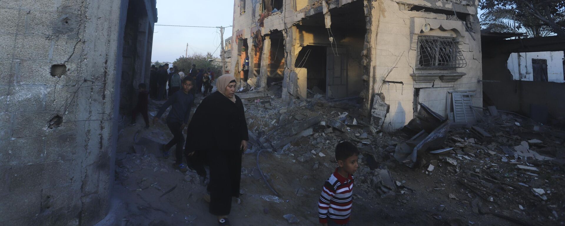 Palestinians walk by a residential building destroyed in an Israeli strike in Rafah, Gaza Strip, Sunday, Feb. 11, 2024 - Sputnik India, 1920, 14.02.2024