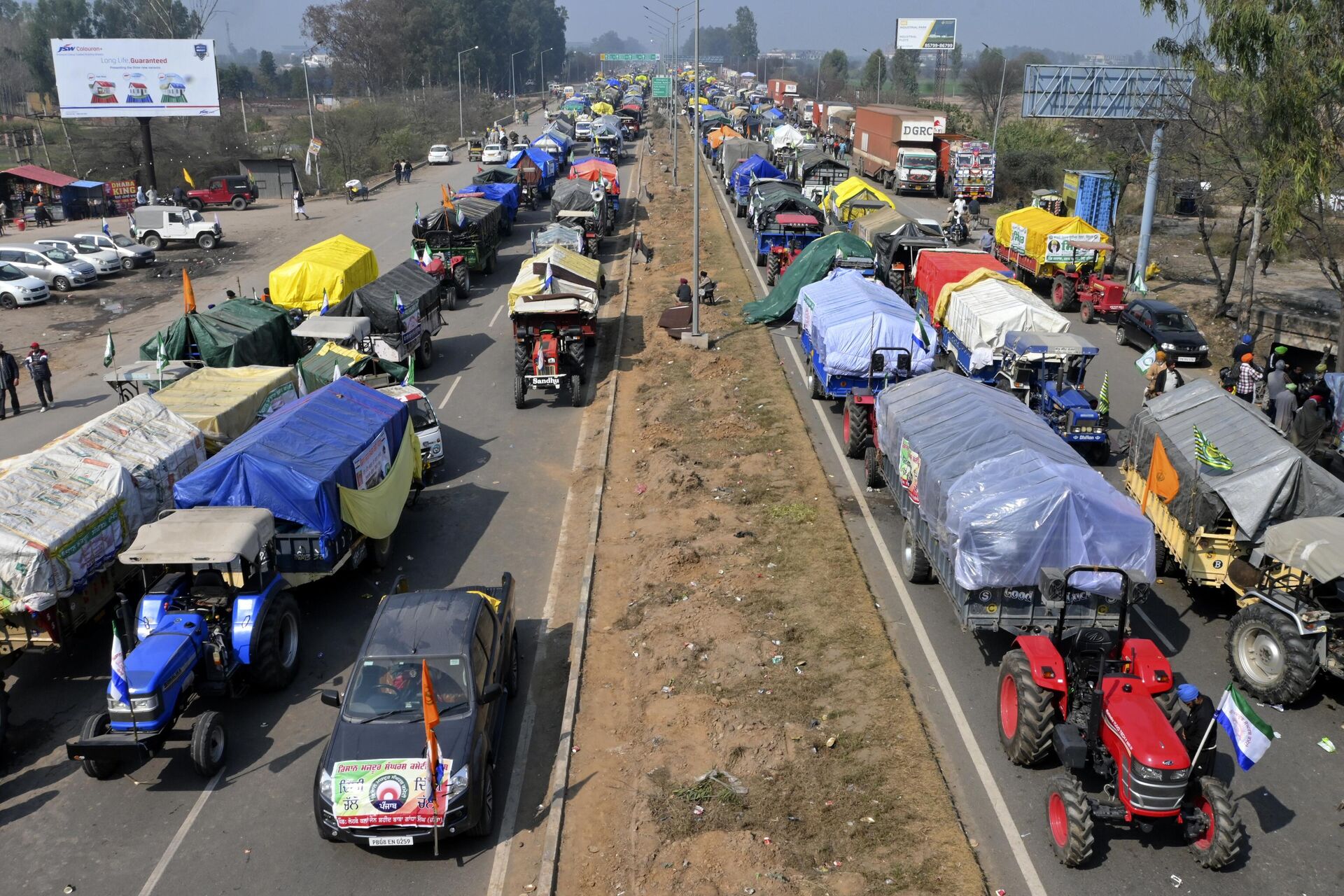 Vehicles belonging to protesting farmers line the highway near Shambhu border that divides northern Punjab and Haryana states, almost 200 km (125 miles) from New Delhi, India, Wednesday, Feb.14, 2024. Protesting Indian farmers Wednesday clashed with police for a second consecutive day as tens of thousands of them tried to march to the capital New Delhi to demand guaranteed crop prices for their produce. (AP Photo/Rajesh Sachar) - Sputnik India, 1920, 26.03.2024
