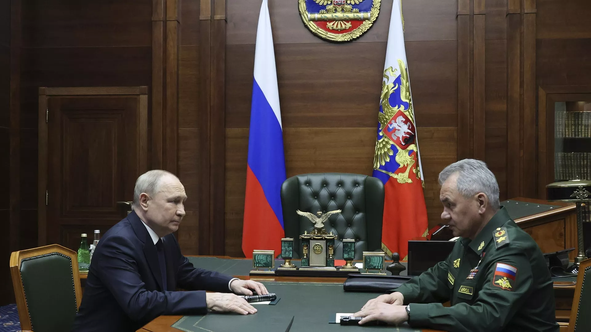 Russian President Vladimir Putin, left, listens to Russian Defense Minister Sergei Shoigu after their meeting with the top military brass in Moscow, Russia, Tuesday, Dec. 19, 2023. 