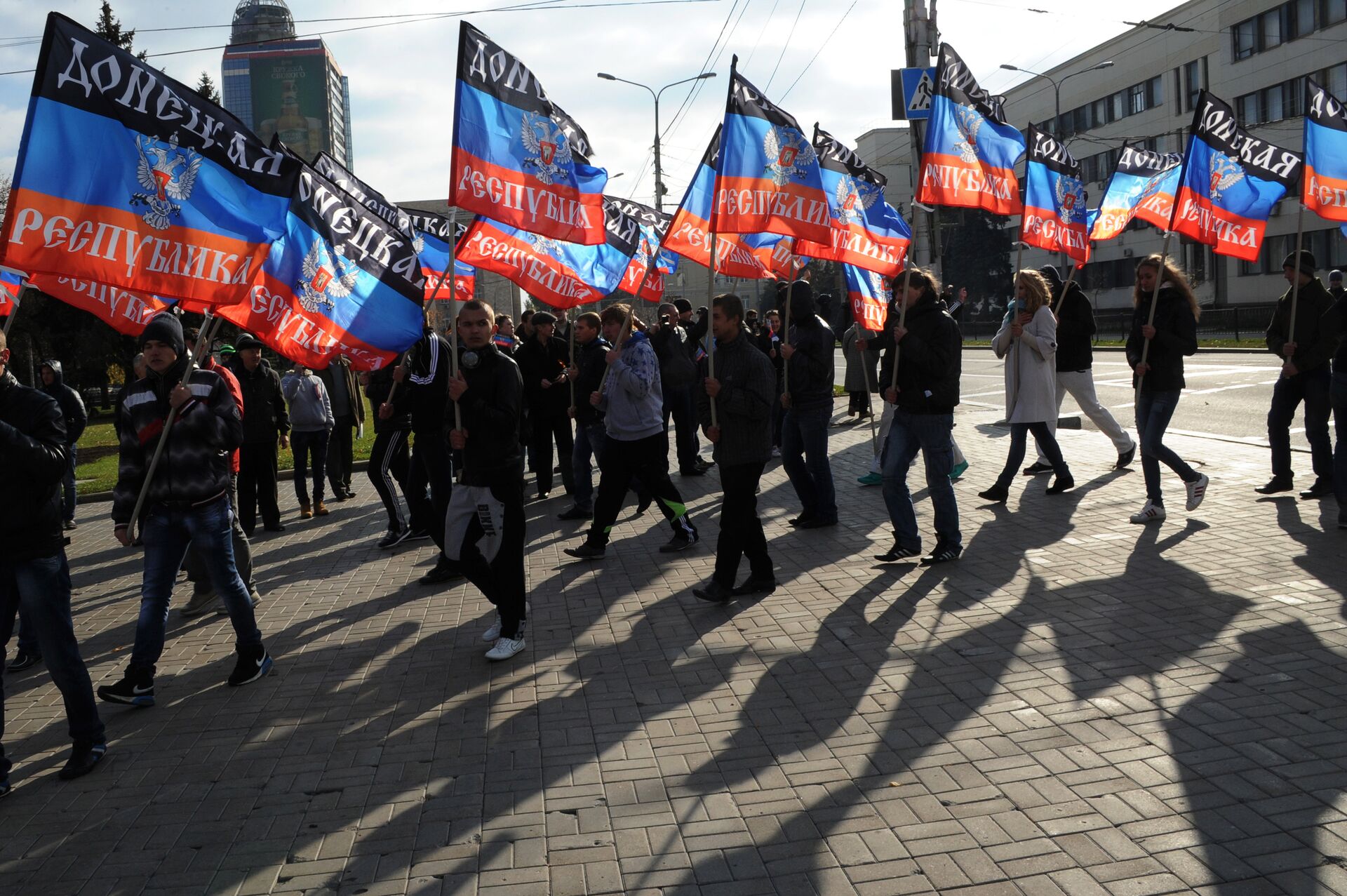 People carry flags of the self-proclaimed Donetsk People's Republic (DPR) during a ceremony for the presentation of the DPR flag at the Lenin square of Donetsk, on October 19, 2014 - Sputnik भारत, 1920, 19.02.2024