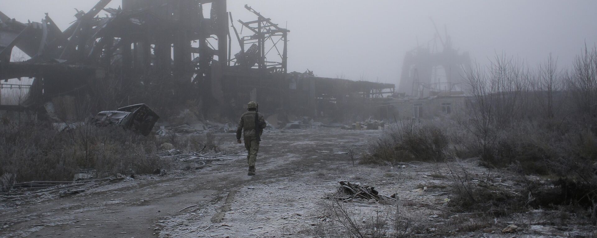 A Ukrainian soldier passes by a destroyed Butovka coal mine as he approaches his front line position in the town of Avdeyevka in the Donetsk region - Sputnik भारत, 1920, 22.02.2024