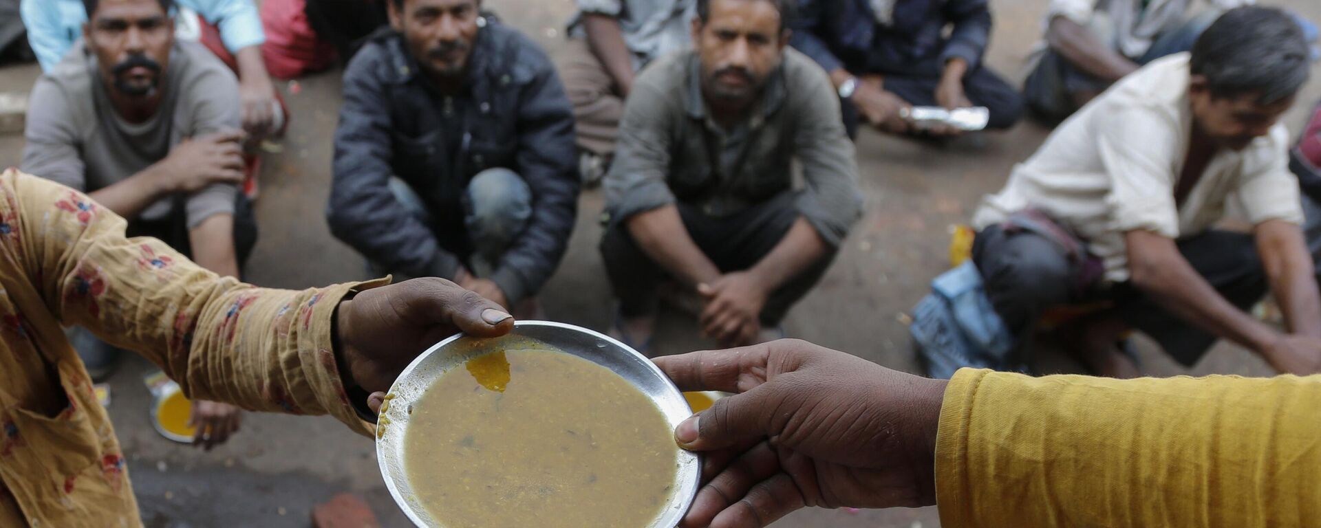 People wait for free food outside an eatery in Ahmedabad, India, on Jan. 20, 2021. - Sputnik India, 1920, 26.02.2024