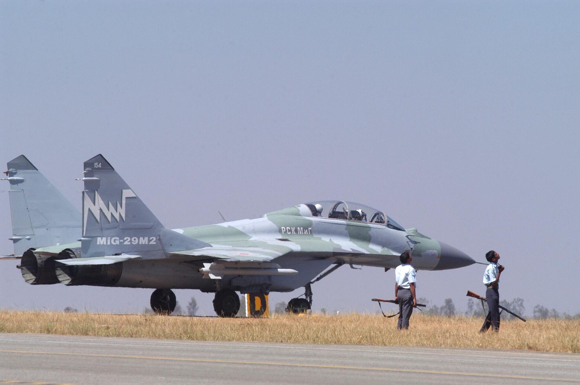 A Russian MiG 29 M2 awaits take off as Indian Air Force Personnel stand with guns to shoot down Pariah Kites at a rehearsal for the inauguration of the Aero India 2005 that begins Wednesday at the Yelahanaka Air Force Station near Bangalore, India, Tuesday, Feb. 8, 2005.  - Sputnik India, 1920, 02.03.2024