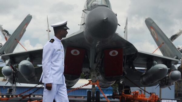 An Indian Navy officer walks past a Mig 29 fighter jet on the deck of the Indian indigenous aircraft carrier INS Vikrant during its commissioning at Cochin Shipyard in Kochi on September 2, 2022. - Sputnik India