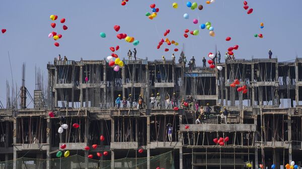 Construction workers watch as Indian Christians release balloons to celebrate the New Year after offering prayers at a Church in Ahmedabad, India, Sunday, Jan. 1, 2023. - Sputnik India