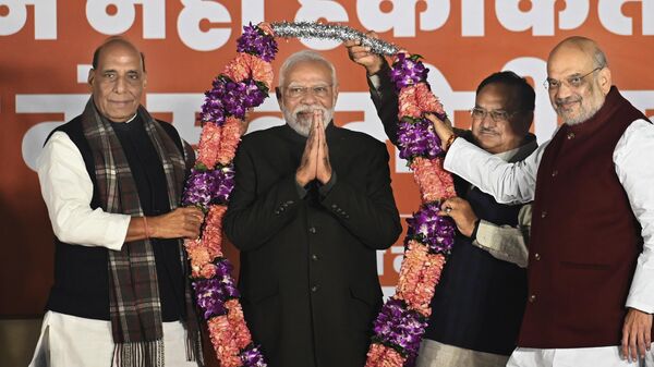 Indian Prime Minister Narendra Modi is garlanded by Defense Minister Rajnath Singh, left, Bharatiya Janata Party (BJP) President Jagat Prakash Nadda, behind, and Home Minister Amit Shah, right during celebrations following BJP's victory in the state elections at the BJP headquarters in New Delhi, India, Sunday, Dec. 3, 2023. - Sputnik भारत