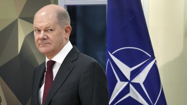 German Chancellor Olaf Scholz stands next to a NATO flag after a speech as part of a visit at the Julius-Leber-Baracks in Berlin, Germany, Tuesday, Feb. 28, 2023.  - Sputnik भारत