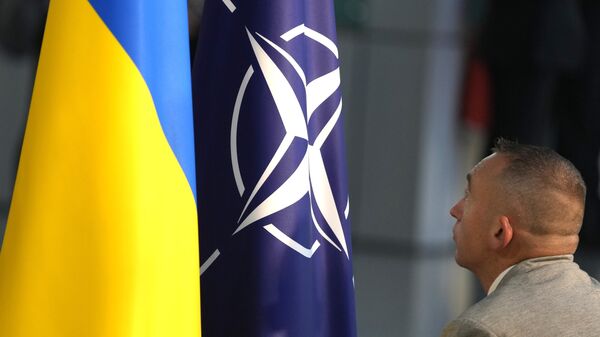 A member of protocol sets up the NATO and Ukrainian flags prior to a media conference of Ukraine's President Volodymyr Zelenskyy and NATO Secretary General Jens Stoltenberg during a meeting of NATO defense ministers at NATO headquarters in Brussels, Wednesday, Oct. 11, 2023.  - Sputnik भारत