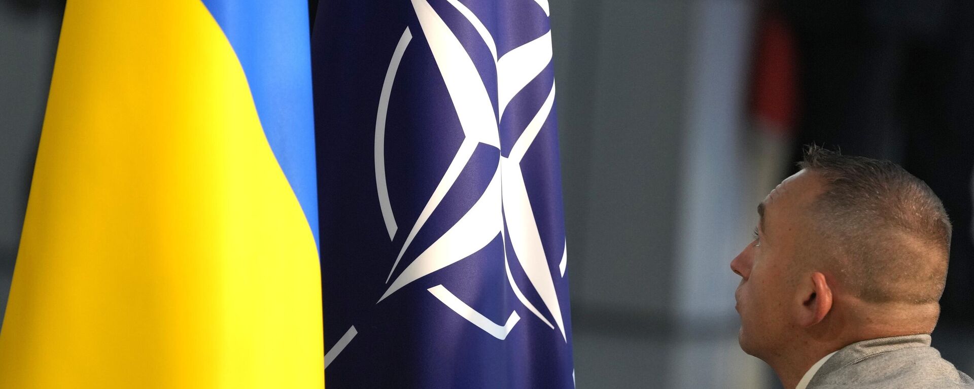 A member of protocol sets up the NATO and Ukrainian flags prior to a media conference of Ukraine's President Volodymyr Zelenskyy and NATO Secretary General Jens Stoltenberg during a meeting of NATO defense ministers at NATO headquarters in Brussels, Wednesday, Oct. 11, 2023.  - Sputnik भारत, 1920, 11.03.2024
