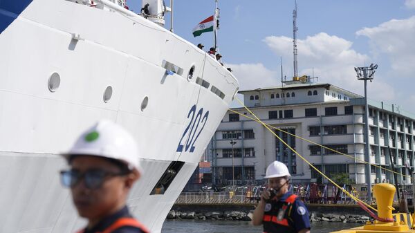 Workers assist Indian Coast Guard Ship Samudra Paheredar as it arrives for a port call in Manila, Philippines on Monday, March 25, 2024. (AP Photo/Aaron Favila) - Sputnik India