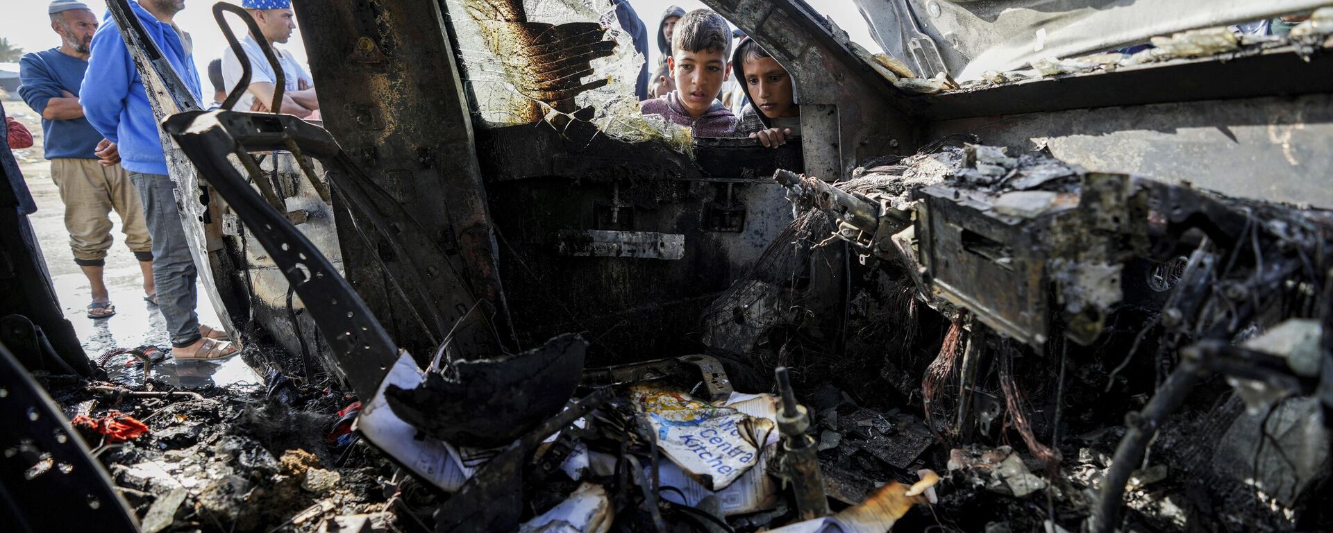 People inspect the site where World Central Kitchen workers were killed in Deir al-Balah, Gaza Strip, Tuesday, April 2, 2024. World Central Kitchen, an aid group, says an Israeli strike that hit its workers in Gaza killed at least seven people, including several foreigners. - Sputnik भारत, 1920, 10.05.2024