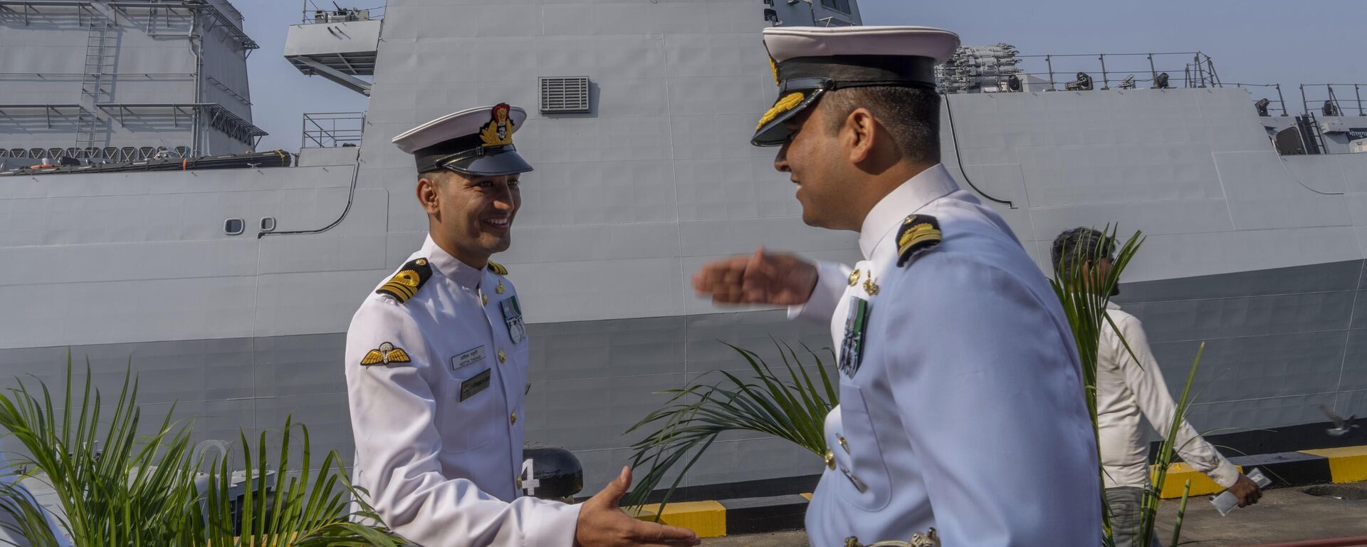 Indian navy officers greets each other during the commissioning ceremony of INS Mormugao, the stealth guided-missile destroyer ship at a naval dockyard in Mumbai, India, Sunday, Dec. 18, 2022.  - Sputnik भारत, 1920, 09.12.2024