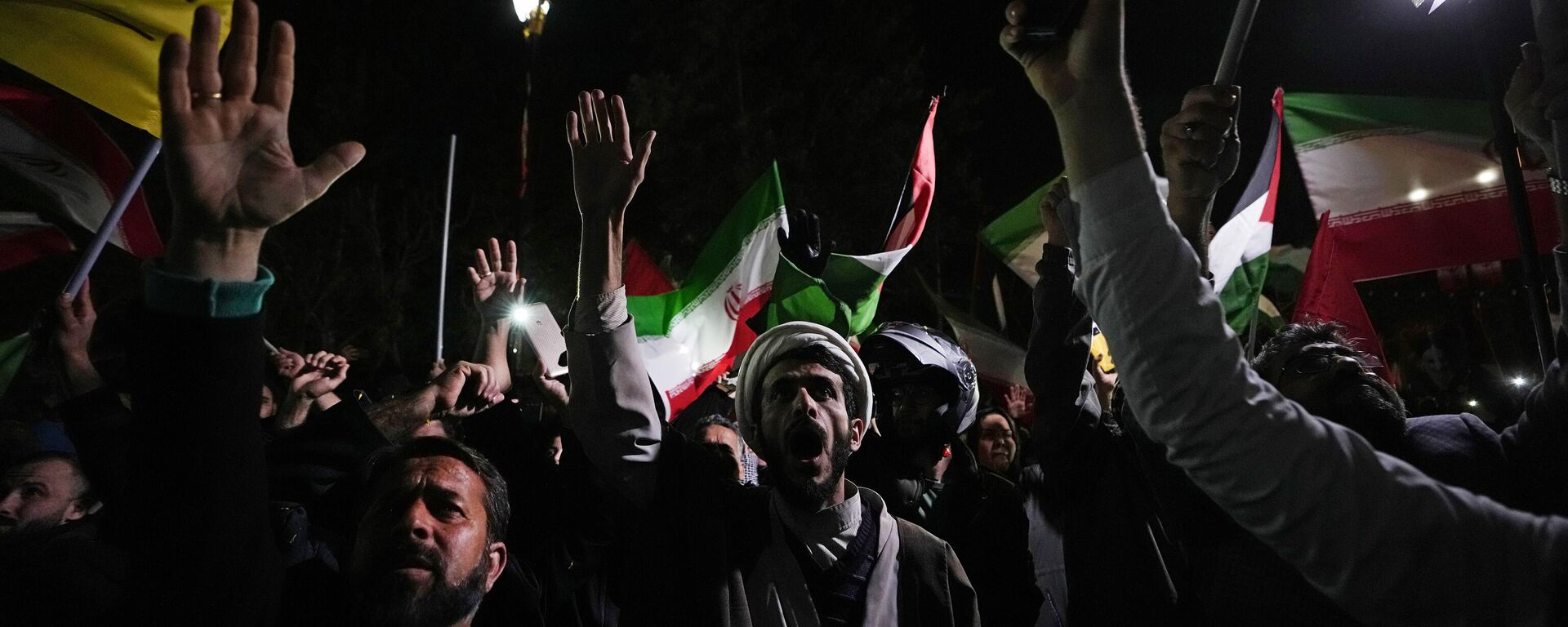 Iranian demonstrators chant slogans during an anti-Israeli gathering in front of the British Embassy in Tehran, Iran, early Sunday, April 14, 2024. Iran launched its first direct military attack against Israel on Saturday. - Sputnik भारत, 1920, 14.04.2024