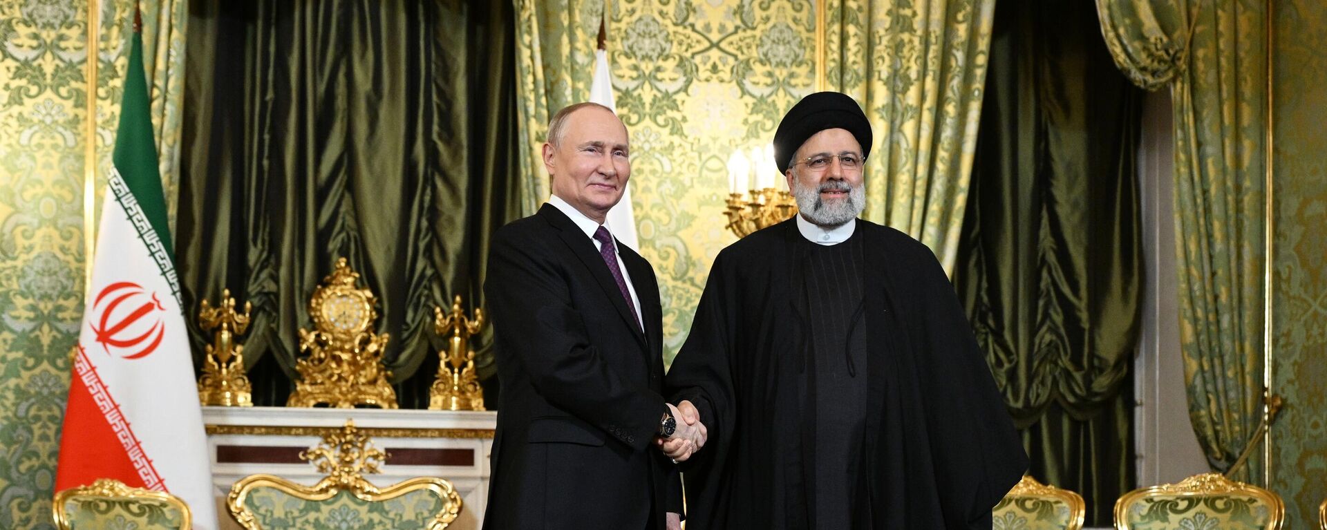 Russian President Vladimir Putin and Iranian President Ebrahim Raisi shake hands as they pose for a photo before a meeting at the Kremlin - Sputnik भारत, 1920, 16.04.2024