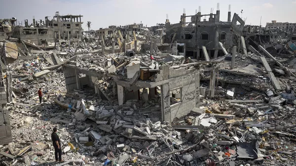 People inspect the damage amid the rubble of buildings destroyed during Israeli bombardment in Khan Yunis, on the southern Gaza Strip on April 16, 2024. - Sputnik भारत