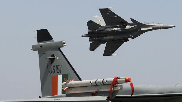 A Sukhoi Su-30 MKI flies over a Jaguar fighter aircraft parked at the static display area on the second day of Aero India 2021 at Yelahanka air base in Bengaluru, India, Thursday, Feb. 4, 2021. - Sputnik भारत