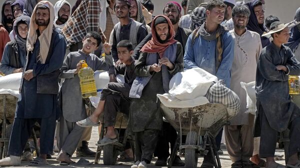 Afghan people wait to receive food rations distributed by a Chinese humanitarian aid group, during the holy month of Ramadan, in Kabul, Afghanistan, Saturday, April 30, 2022. - Sputnik India