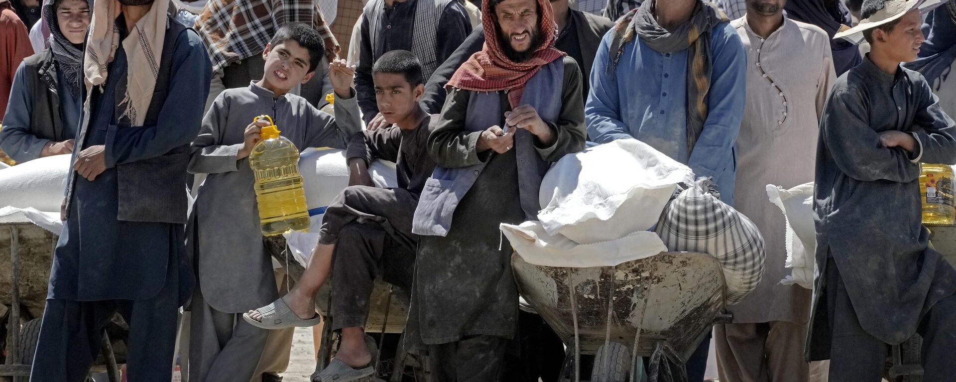 Afghan people wait to receive food rations distributed by a Chinese humanitarian aid group, during the holy month of Ramadan, in Kabul, Afghanistan, Saturday, April 30, 2022. - Sputnik India, 1920, 08.06.2024