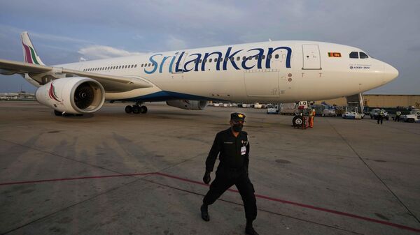 A Sri Lankan Airlines plane carrying remains of Priyantha Kumara, a Sri Lankan employee who was lynched by a Muslim mob in Sialkot arrives as a security officers guards the area in Colombo, Sri Lanka, Dec. 6, 2021. - Sputnik भारत