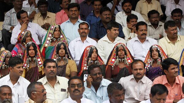 Indian tribal women sit with men of the Banjara community during a protest rally demanding their rights outside the venue of a public hearing held by the National Commission of Scheduled Castes in Bangalore, India, Tuesday, July 2, 2013. The commission is responsible for recognizing the communities who suffer from social, educational and economic backwardness arising out of age-old practice of untouchability and safeguard their interests according to Indian constitution. (AP Photo/Aijaz Rahi) - Sputnik India