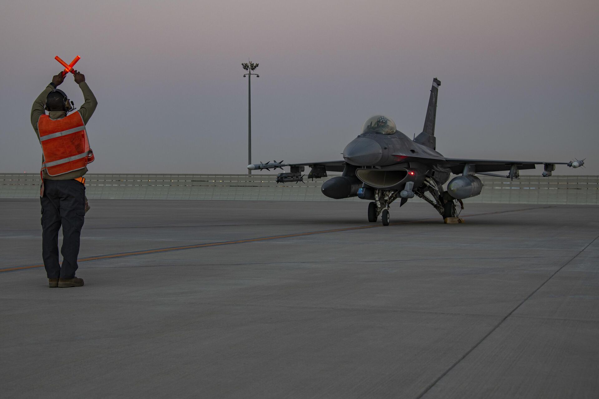 In this handout photo from the U.S. Air Force, an airman guides an F-16 Fighting Falcon during training at Al-Udeid Air Base, Qatar, Jan. 24, 2022.  - Sputnik India, 1920, 15.06.2024