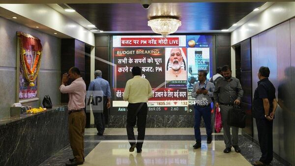 People walk past an electronic signage displaying news of India's federal budget inside the Bombay Stock Exchange (BSE) building in Mumbai, India, Wednesday, Feb. 1, 2023.Prime Minister Narendra Modi’s government presented to Parliament on Wednesday an annual budget of $550 billion that calls for ramping up capital spending by 33% to spur economic growth and create jobs ahead of a general election next year. (AP Photo/Rajanish Kakade) - Sputnik India